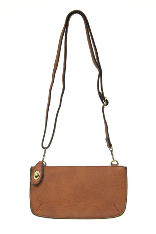 Brown leather handbag with a strap on a white background