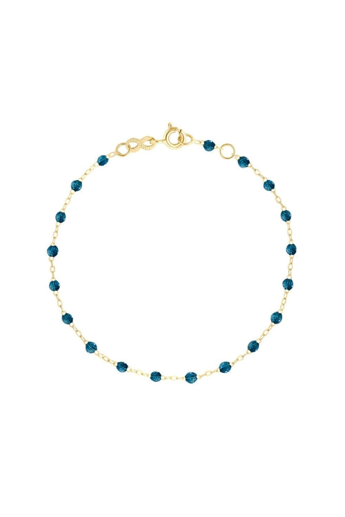 Gold bracelet with blue beads on a white background